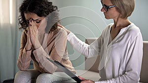 Female psychologist comforting depressed young lady patient, mental health