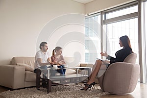 Female psychologist working with young unhappy family couple hav