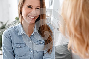 Female psychologyst therapy session with client indoors sitting patient smiling cheerful close-up