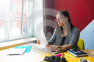 Female publication specialist reading resumer during work day in co-working