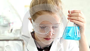 Female Pupil Conducting Chemistry Experiment In Science Class