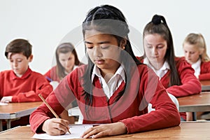 Female Pupil At Desk Taking School Exam