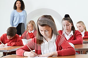 Female Pupil At Desk Taking School Exam photo