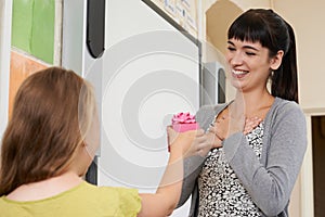 Female Pupil Giving Teacher End Of Term Gift