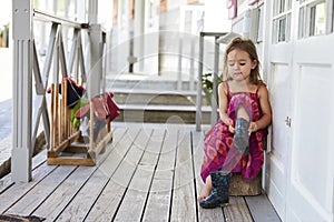 Female Pupil At Montessori School Putting On Wellington Boots