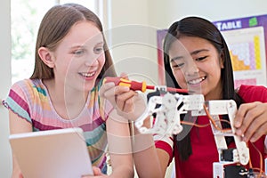 Two Female Pupils In Science Lesson Studying Robotics