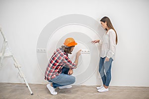 Female purchaser talking to the construction worker and looking unpleased