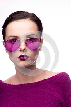 female in a purple sweater, purple glasses with purple lipstick on her lips