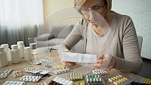 Female putting glasses and reading medicine instruction, pharmaceutical industry