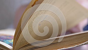 A Female Quickly Flips Through the Pages of a Shabby Old Book. 4K. Close up