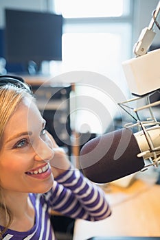 Female radio host broadcasting in studio