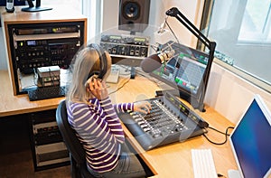 Female radio host operating sound mixer