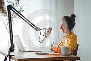 Female radio host recording and broadcasting her podcast from homemade studio