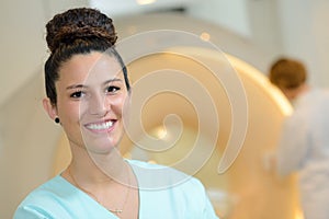 Female radiologist with colleagues standing by mri machine