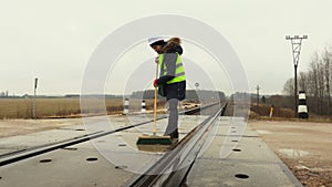 Female railway worker clean railway crossing in winter