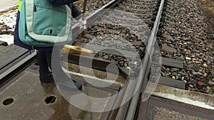 Female railway worker using brush on railway