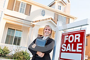 Female Real Estate Agent in Front of For Sale Sign and Beautiful House