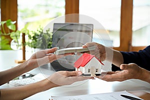 A female real estate agent receives a house loan payment from her client. cropped image