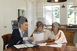 Female real estate agent and senior couple discussing over documents