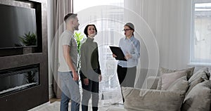 Female real estate agent showing modern apartment to young caucasian family buying new apartment. Real estate concept.