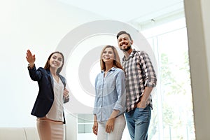 Female real estate agent showing new house to couple