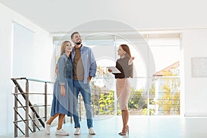 Female real estate agent showing new house to couple