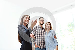 Female real estate agent showing new house to couple