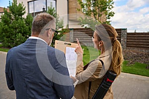 Female real estate agent shows blueprint of house to client