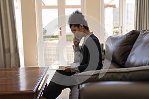 Female real estate agent talking on mobile phone while using digital tablet in living room