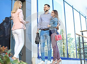 Female real estate agent welcoming couple to show house