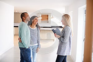 Female Realtor Showing Couple Interested In Buying Around House photo