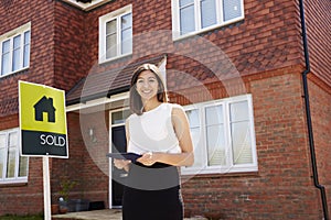 Female Realtor Standing Outside Residential Property