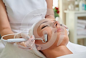 Female receiving microcurrent therapy in spa cosmetologist professional services photo