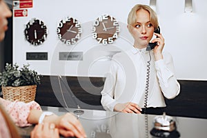 Female receptionist in hotel talking on the phone at work