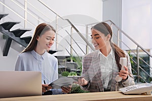 Female receptionists working at desk in hotel