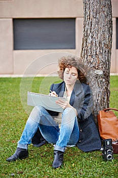 Female redhead art student drawing outdoors