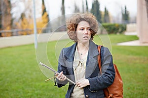 Female redhead student carrying notebook