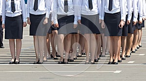 Female regiment in black skirts and white shirts keep a system