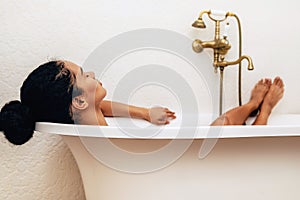 Female relaxing in bathtub