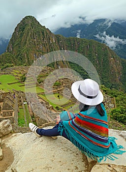 Female Relaxing on the Cliff Looking at Machu Picchu Inca Ruins, Cusco, Urubamba, Archaeological site in Peru