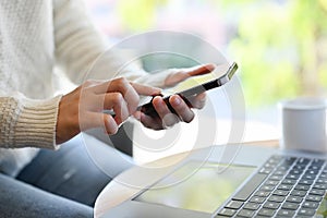 A female remote working at the coffee shop, using her smartphone to chat with someone. cropped