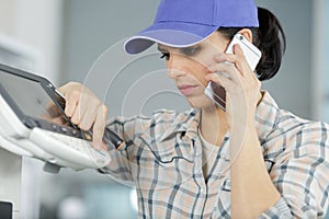 female repairer on phone fixing printer