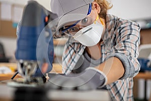 Female repairman carpenter cutting joining wooden planks