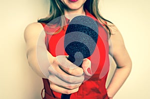 Female reporter with black microphone making interview photo