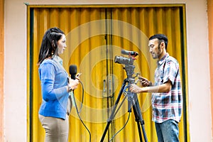 a female reporter and a cameraman prepare for news recording