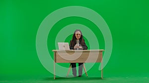 Female reporter at the desk isolated on chroma key green screen background. Full shot african american woman tv news