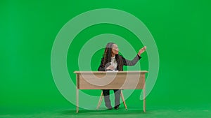 Female reporter at the desk isolated on chroma key green screen background. Full shot african american woman tv news