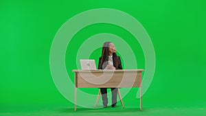 Female reporter at the desk isolated on chroma key green screen background. Full shot african american woman tv news