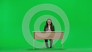 Female reporter at the desk isolated on chroma key green screen background. Full shot african american woman tv news