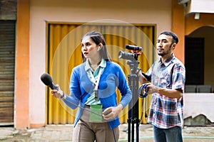 a female reporter hunting for news with a cameraman